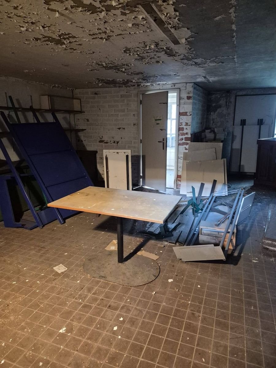 Ruimte met een tafel en rondslingerend materiaal voor de opruiming