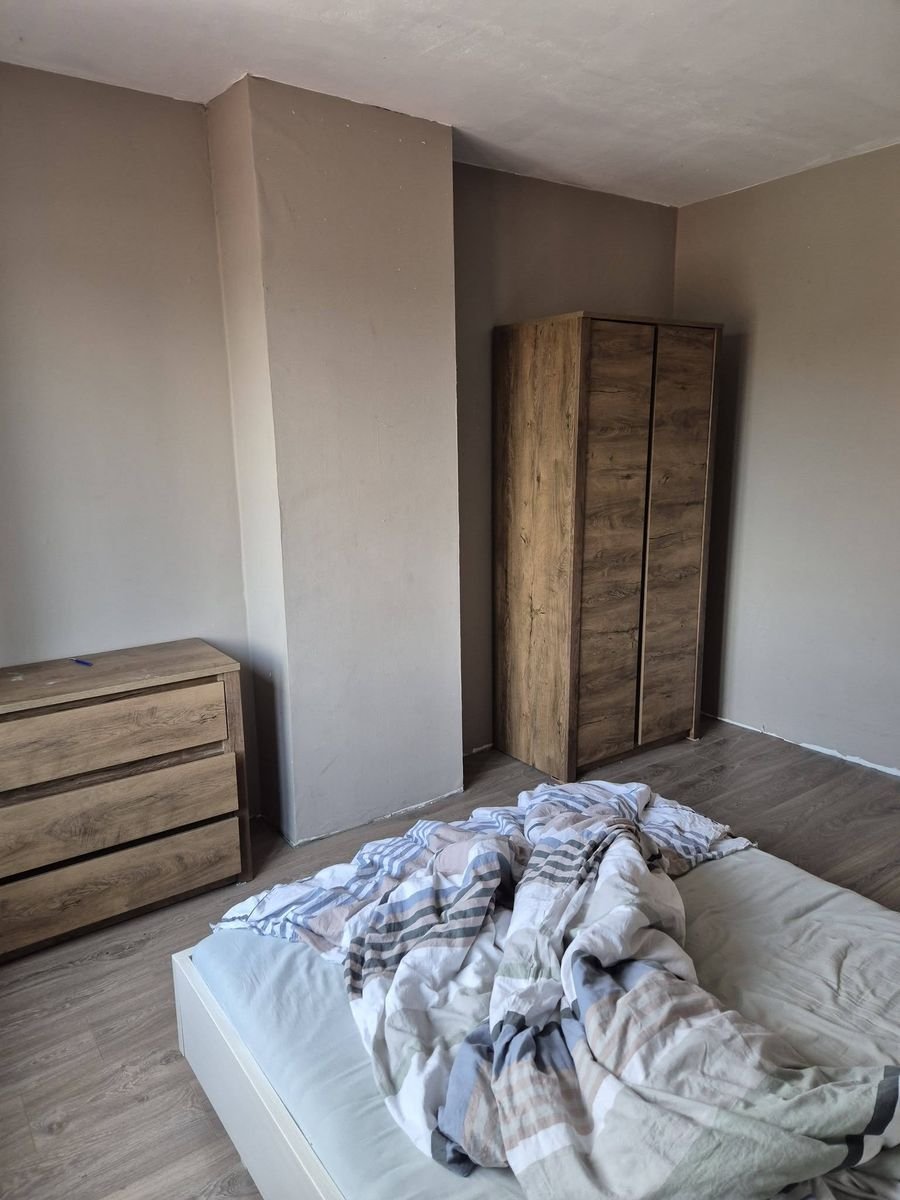 Slaapkamer met bed, kast en dressoir voor de opruiming
